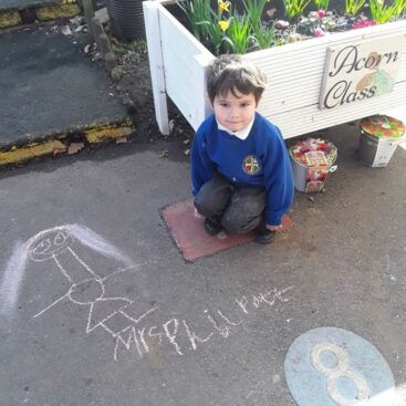 pupil in eyfs showing a chalk drawing they made of mrs philpott, a teacher at horton kirby primary school