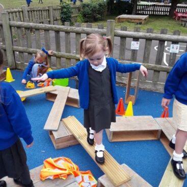 pupil in eyfs at horton kirby primary using a balance beam to practise skills