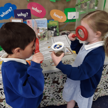 pupils in acorn class (EYFS) at horton kirby primary school using magnifying glasses in their geography lesson