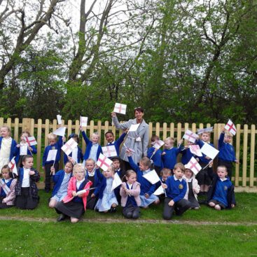 whole of eyfs class waving their flags they made for st georges day at horton kirby primary school - acorn class