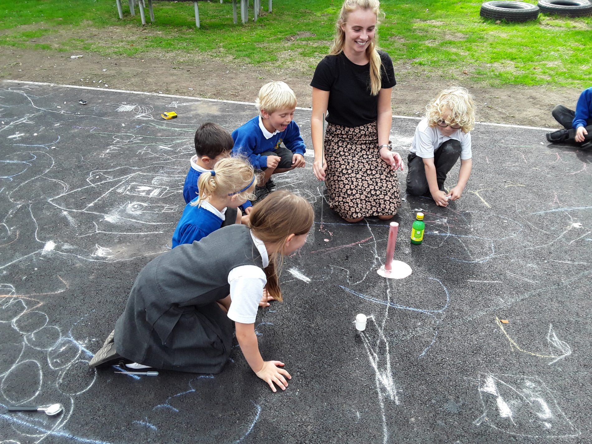 children drawing on the playground with chalk
