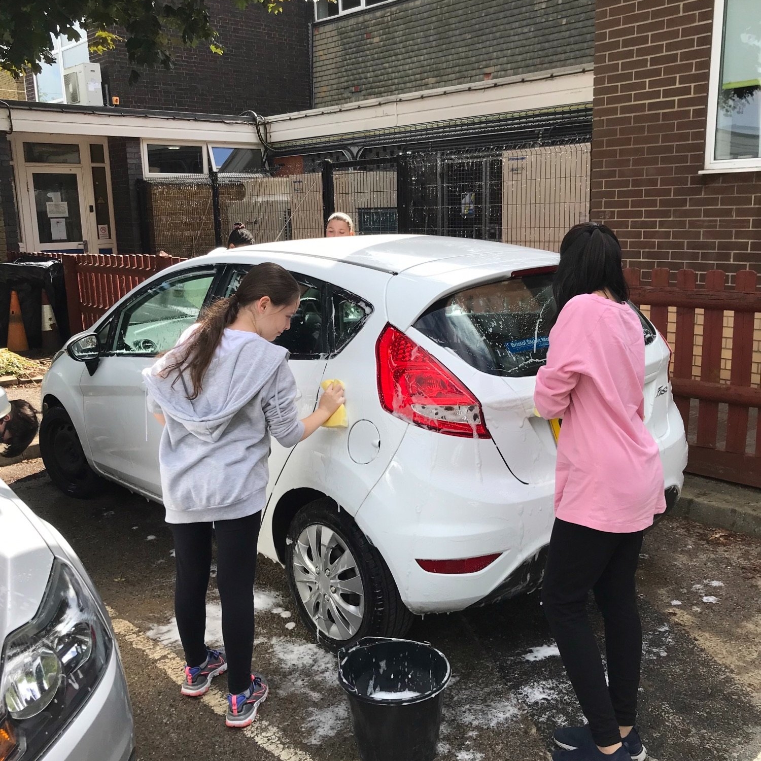 kids cleaning staff cars for enterprise week at horton kirby primary school