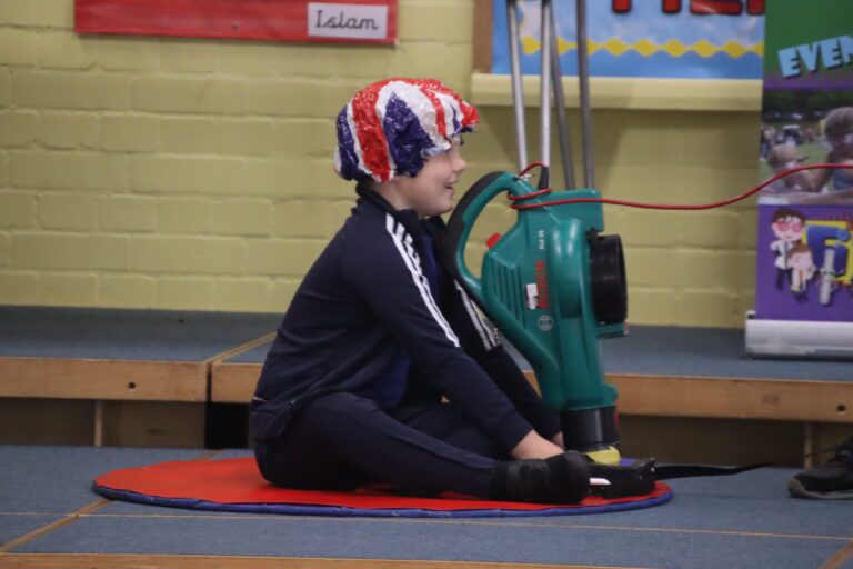 Fizz Pop Science child using a makeshift hoverboard at Fizz Pop Science club at Horton Kirby primary