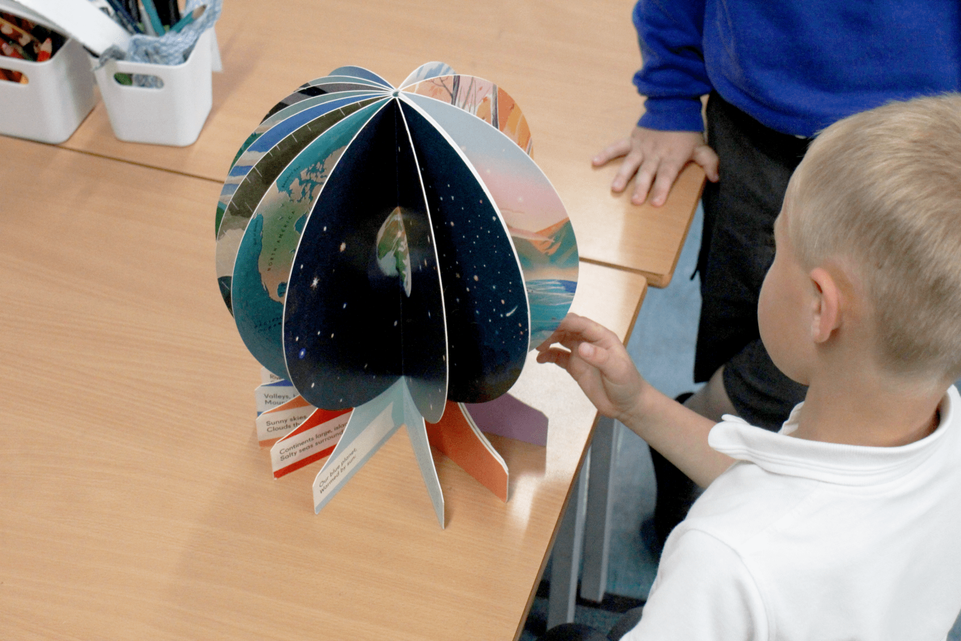 globe pupil looking at a geographic 3d globe in geography at horton kirby primary school