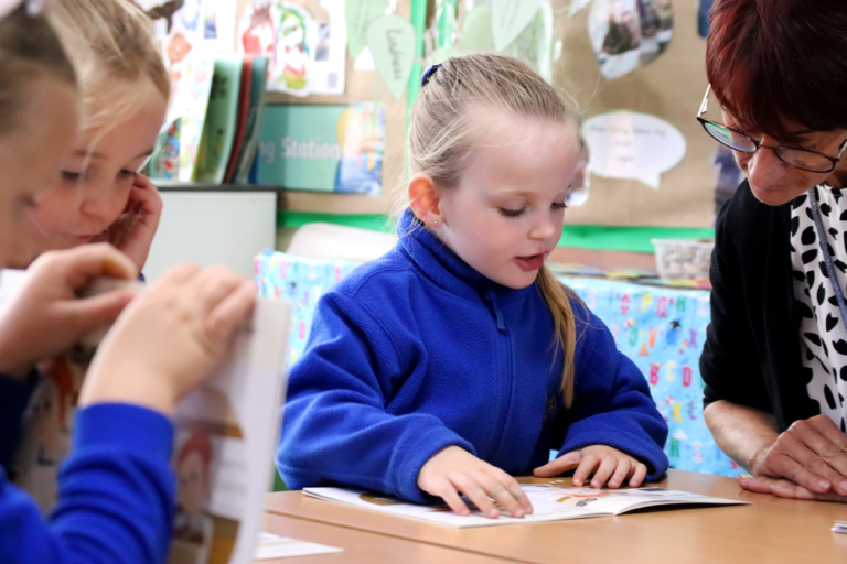 eyfs reading pupil reading to the teacher in early years foundation stage at horton kirby primary school
