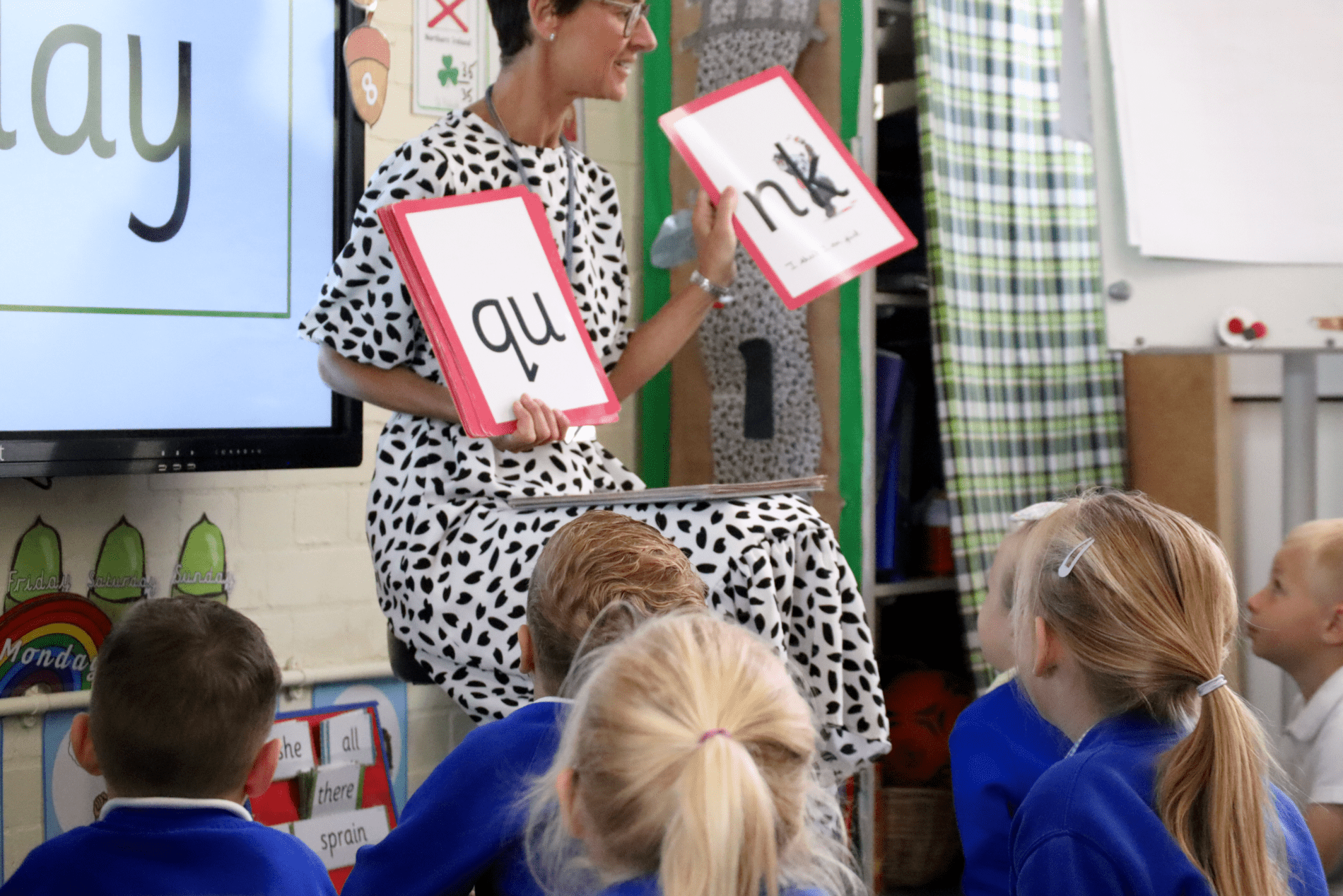 eyfs class learning about phonics with teacher holding phonics cards at horton kirby primary school
