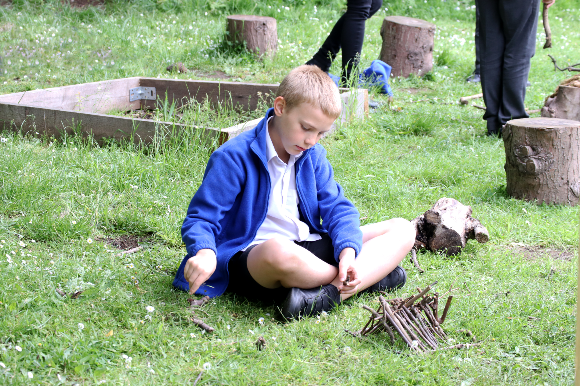 kid building a hut at forest school at horton kirby primary school