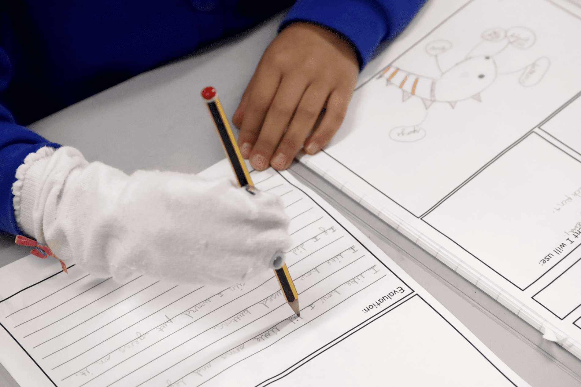 DT socks pupil writing in a DT workbook with their sock puppet at horton kirby primary school