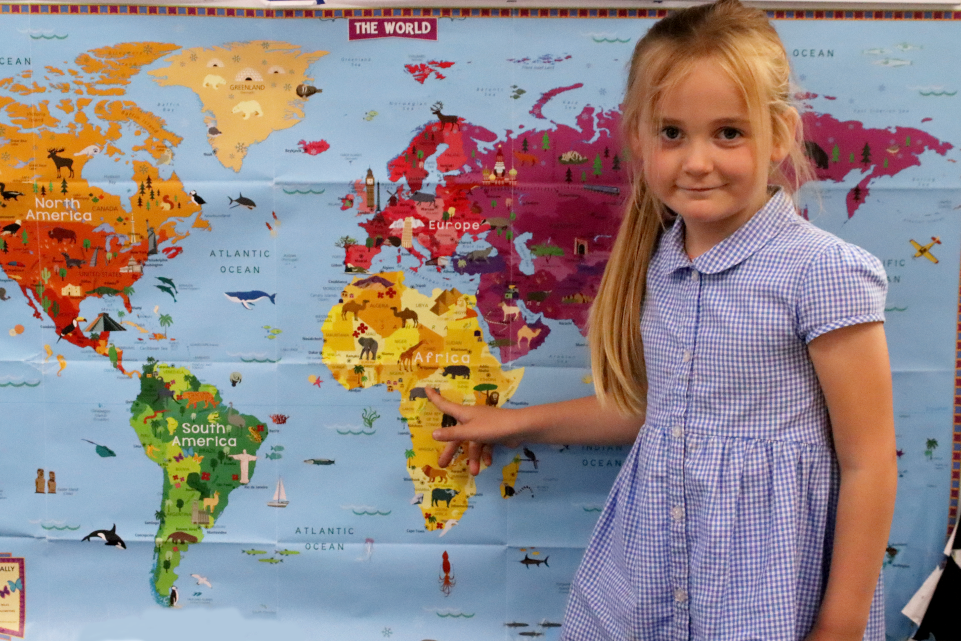 pupil in key stage one pointing at africa on the map at horton kirby primary school