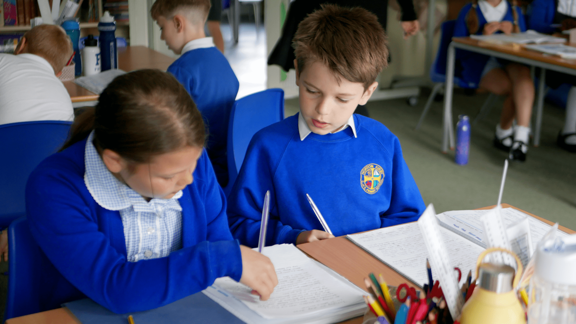 two pupils correcting each others work in english at horton kirby primary school