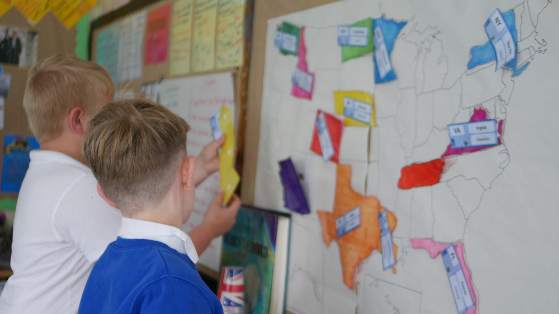 geography match countries two pupils matching countries to the correct place on a map in a geography lesson at horton kirby primary school