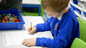 ks1 maths pupil looking down at worksheet of maths at horton kirby primary school