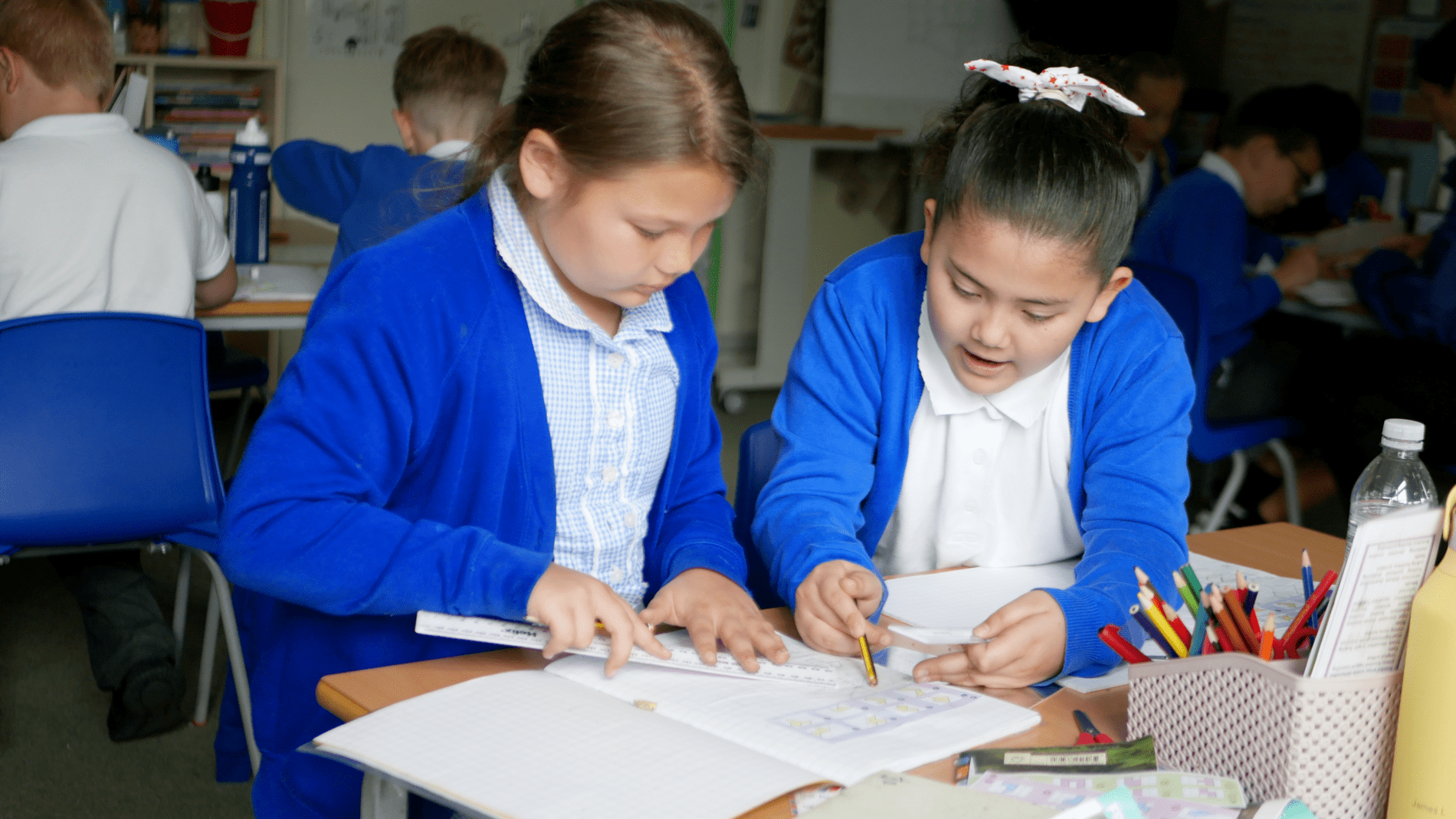 helping maths two pupils helping each other in maths class at horton kirby primary school
