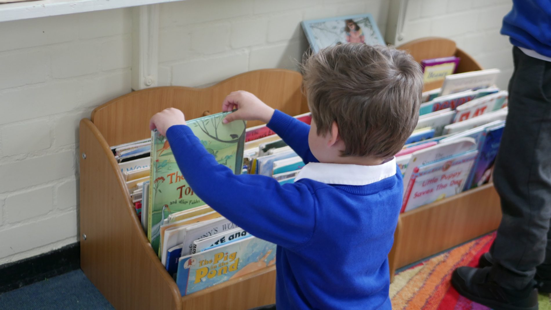 Boy Picking Book boy picking our a book from the class' book corner at horton kirby primary school