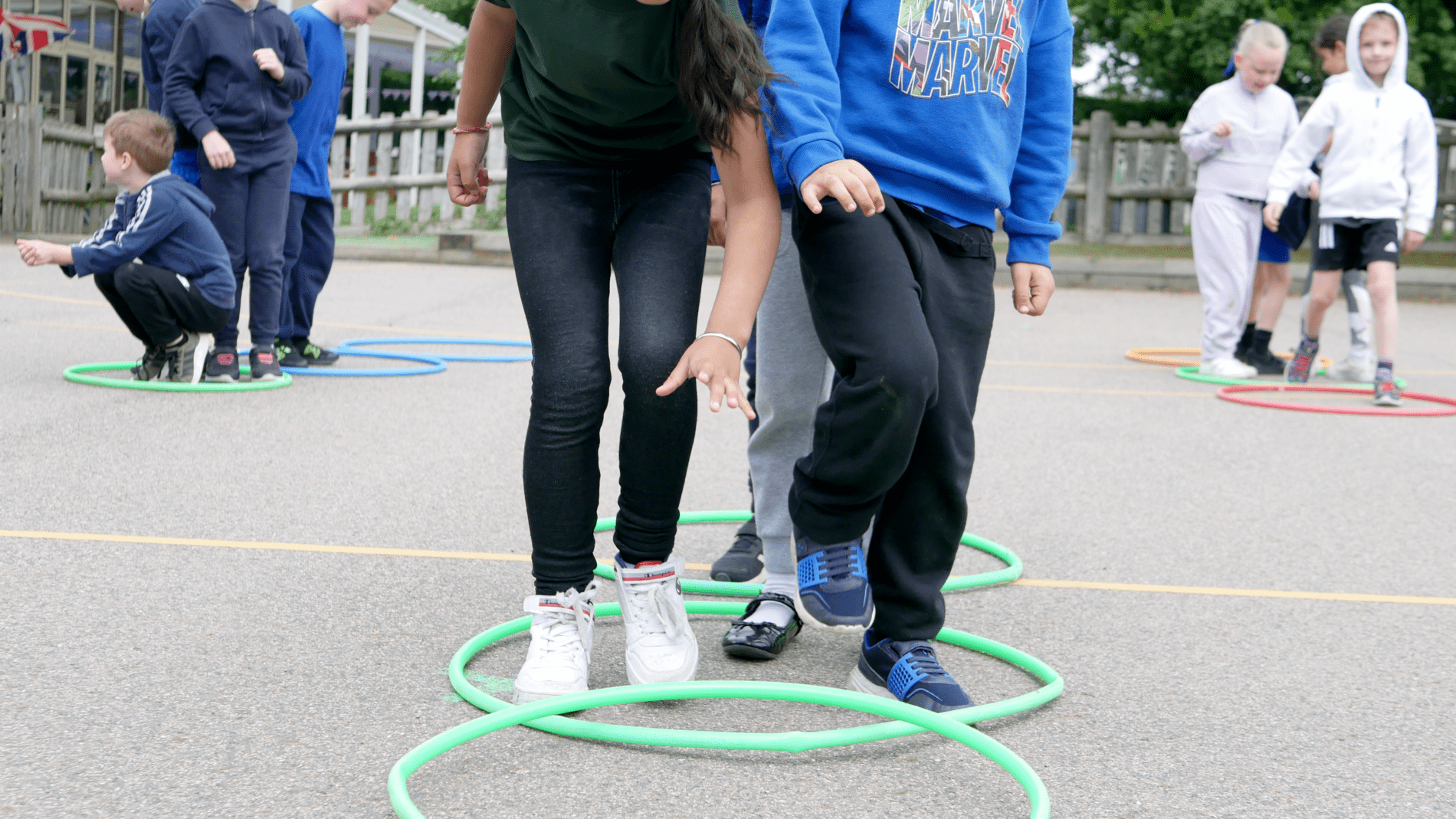 PE pupils stepping into hoops as team building activity in PE lesson at horton kirby primary school
