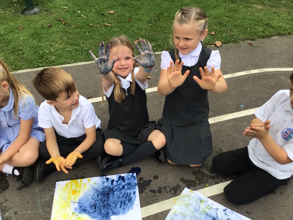 pupils showing painted hands in an art class