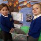 two pupils from horton kirby cofe primary school receiving two giant african snails from aletheia academies trust